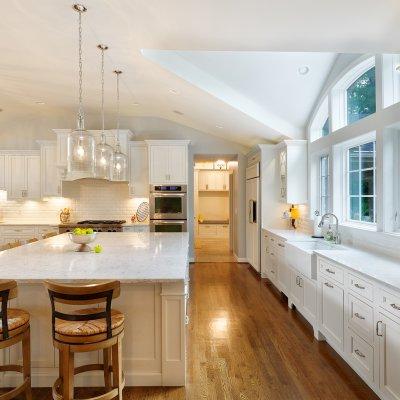 Long kitchen counter with dormer ceiling and large arched windows